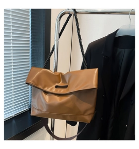 Detail view of large caramel tote bag featuring soft leather and twisted rope shoulder straps