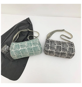 Detail of checkered nylon tote bags in green and black with wide patterned straps