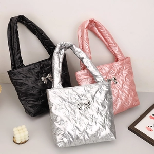 Three quilted puffy tote bags with metallic finish and bow patterns in black, silver and pink