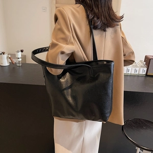 Large capacity vintage black leather tote bag for women showing a stylish shoulder carry