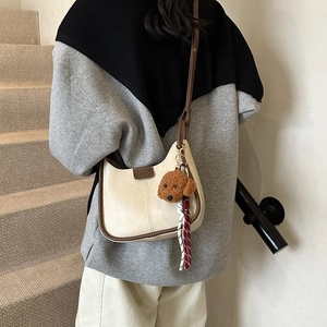 Minimalist cream shoulder bag with brown trim and cute teddy bear charm for women