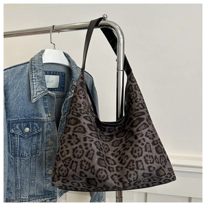 Detail of grey leopard print tote bag hung with a classic denim jacket