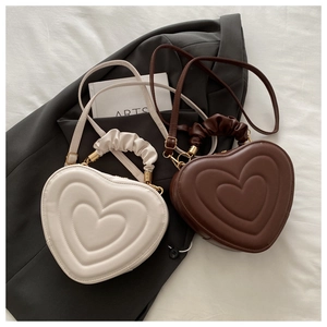 Détail de sacs à main en forme de cœur avec texture matelassée et poignée froncée