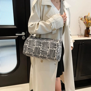 Checkered large capacity nylon tote bag with wide shoulder strap worn by a model