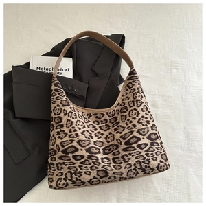 Detail of leopard print hobo bag with brown strap on black blazer for a retro look