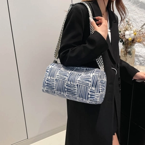Blue and white checkered nylon tote bag with wide woven strap worn by a model