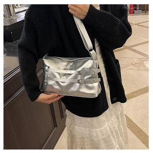 Detail of silver metallic PU shoulder bag with decorative buckles and glossy finish