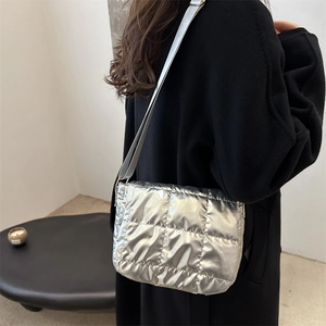 Metallic silver quilted crossbody bag with square stitching and adjustable strap