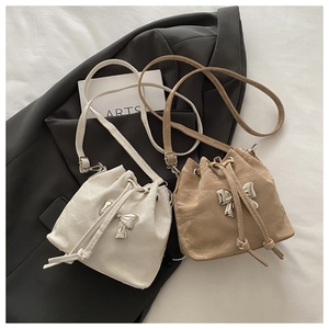Detail of drawstring bucket bag with shiny silver butterfly knot and marble texture