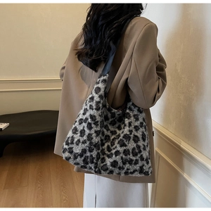 Close-up of stylish leopard print plush tote bag with fuzzy texture and black shoulder strap
