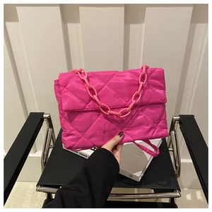 Détail du sac matelassé rose fuchsia avec chaîne mate épaisse et texture nuageuse douce