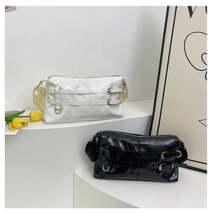 Close-up of black and white glossy PU shoulder bags with silver metal buckle decor