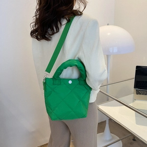 Modern bright green quilted bucket bag with crossbody strap and top handle for women