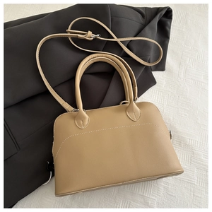 Detail of light brown shell bag with lychee texture and contrasting white stitching