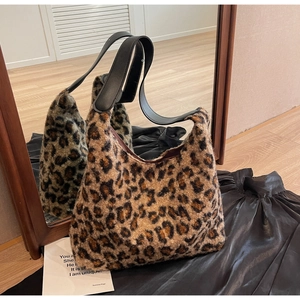 Detail of plush leopard print tote bag with black faux leather strap and soft faux fur texture