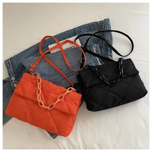 Vue détaillée de sacs bandoulière en nylon matelassé orange et noir avec chaîne épaisse
