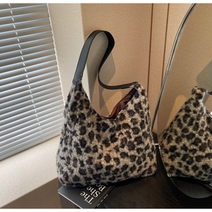 Detail of soft leopard print plush faux fur material and leather strap on a hobo tote bag