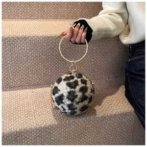 Detail of leopard print plush evening bag with gold circular handle and chain strap