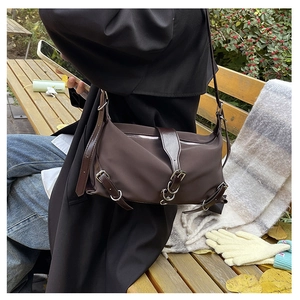 Detail of dark brown crossbody bag with high-density nylon and retro silver buckles