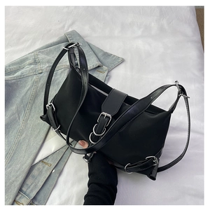 Detail of black nylon baguette bag with silver metal rings and adjustable belt buckles