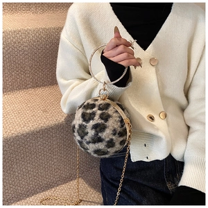 Detail of spherical leopard print evening bag with crystal ring handle and gold chain