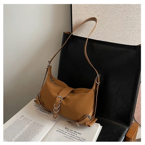 Close-up of caramel brown baguette bag featuring silver buckles and smooth matte leather finish