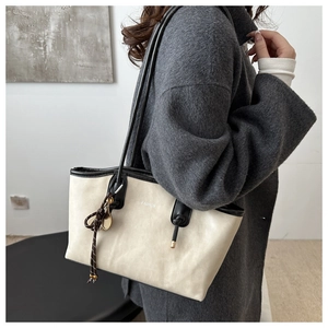 Dettaglio della borsa tote crema con bordo nero e scritte Fashion bianche stampate