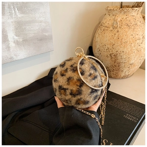 Detail of leopard print plush sphere bag with gold rhinestone ring handle and chain