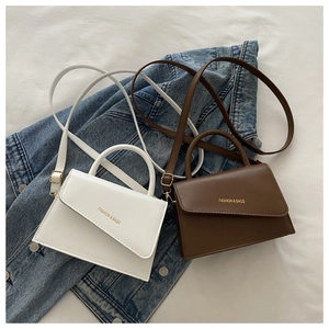 Detail view of mini leather shoulder bags in white and brown with asymmetrical flaps