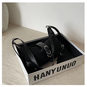Detail of black chic baguette bag with silver buckles in a stylish gift display box