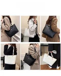 Detail view of quilted tote bag in black and white with metal hardware accents