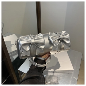 Detail of silver metallic cylindrical handbag with large decorative bows and slim strap