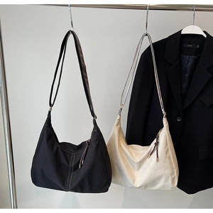 Vue détaillée de grands sacs fourre-tout en suède noir et beige avec détails zippés