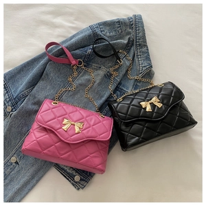 Close-up of quilted chain bags with gold bow clasps in pink and black leather colors