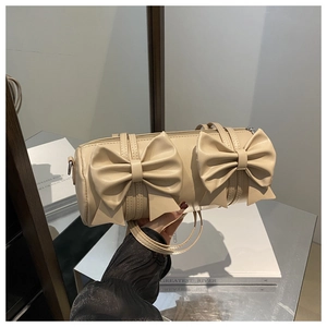Detail of cream Boston bag featuring dual bow design and sleek leather texture
