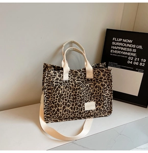 Detailed view of leopard print canvas tote bag with front pockets and sturdy handles