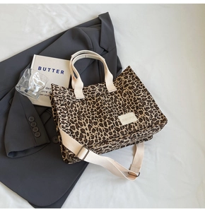 Close-up of leopard print canvas tote bag with adjustable strap and textile brand tag