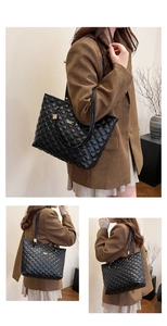Detail of black quilted tote bag with gold metal plate and textured diamond stitching