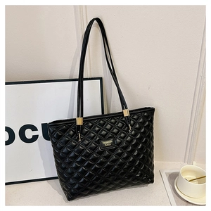 Close-up of black quilted PU leather tote bag featuring gold metal hardware and logo