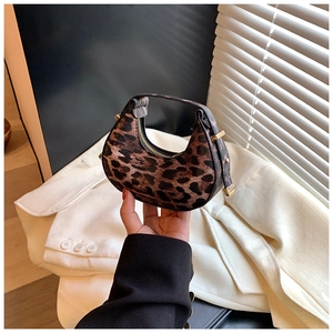 Detailed view of crescent bag featuring leopard print texture and black leather strap