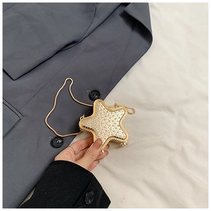 Détail d'une pochette de soirée dorée en forme d'étoile ornée de strass brillants