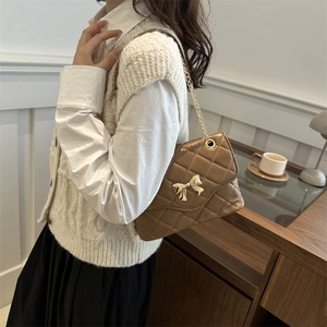 Elegant brown quilted crossbody bag with gold bow clasp and metal chain strap for women