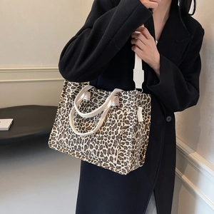 Large capacity leopard print canvas tote bag with adjustable strap worn by model