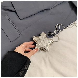 Détail d'un mini sac argenté étincelant en forme d'étoile orné de strass brillants