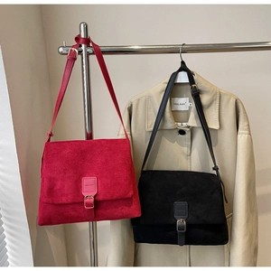 Detail of vintage matte suede shoulder bags with decorative leather straps and metal buckles
