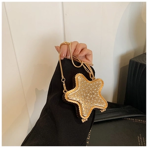 Détail d'une pochette de soirée dorée en forme d'étoile avec strass et chaîne