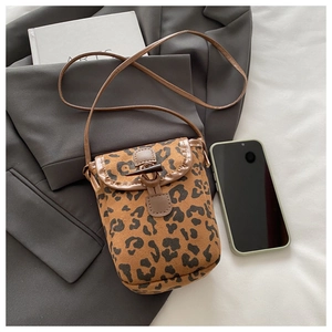 Detail of leopard print phone bag featuring suede texture and wooden toggle closure