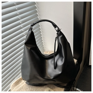 Detail of black crescent hobo bag with sleek matte texture and stylish leather zipper pull