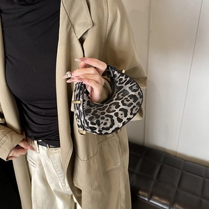 Fashionable leopard print hobo bag with gold buckle shown in a lifestyle setting