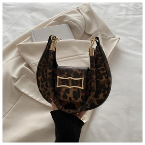 Detailed close-up of leopard print crescent bag with elegant gold metal buckle hardware